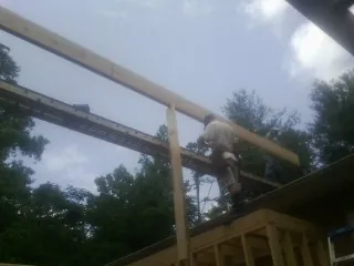 Carpenter setting a ridge beam over a new addition frame — Ice Dam Removal by Roofing Brothers in Hightstown