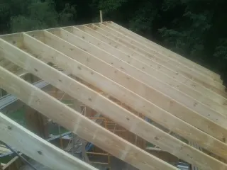 New roof rafters set over an addition before sheathing in Hightstown