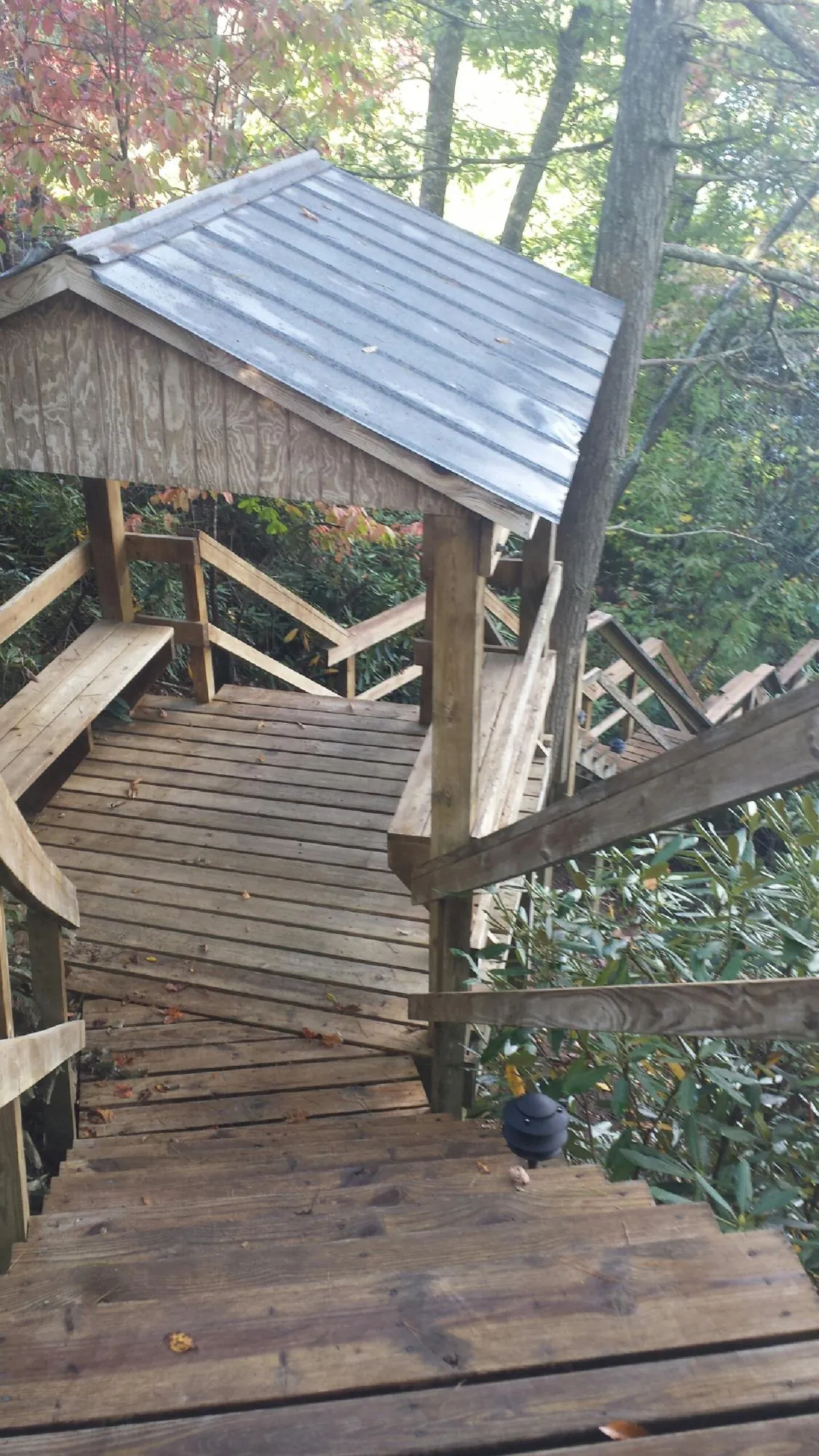 Metal roofed shelter over wooden steps on a wooded walkway — Skylight Repair & Installation work by our crew in Hightstown